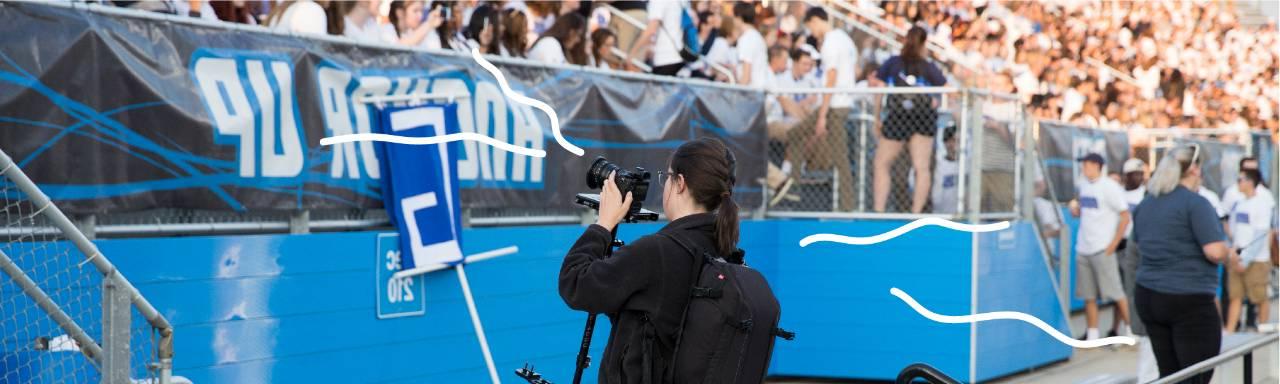 A student taking photos of students in Lubbers Stadium